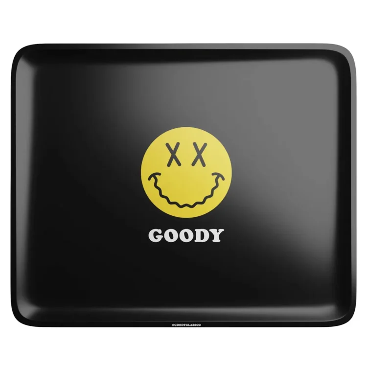 En rektangulær bakke med afrundede hjørner i sort farve pryder overfladen. Mønstret viser en stor, stiliseret ansigtstræk med en legende og farverig grafik i nuancer af blå, gul og rød. Bakken har en mat finish, der giver en blød tekstur. Dimensionerne er 280 x 356 mm, hvilket gør den praktisk til forskellige anvendelser.