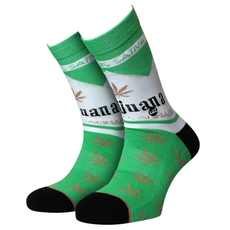 Crew-sokkerne præges af et farverigt cannabisblad-mønster i grønne nuancer på en sort baggrund. Materialet fremstår blødt og strækbart, hvilket indikerer en god pasform. Sockens ribbede kant øverst giver ekstra støtte, mens den flade søm ved tæerne sikrer komfort. Mønsteret dækker hele sokken og skaber et iøjnefaldende design.