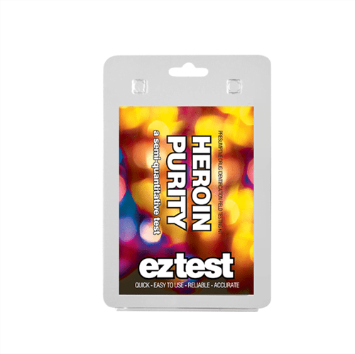EZ Test blisterpakken præsenterer en rektangulær, gennemsigtig plastbeholder med en hvid baggrund. Indholdet består af en lille ampul med en brun væske og en farvet indikator, som skifter nuance ved kontakt. Pakken har en tydelig, sort skrift med instrukser og advarsler, samt et logo i øverste hjørne. Designet er enkelt og funktionelt.