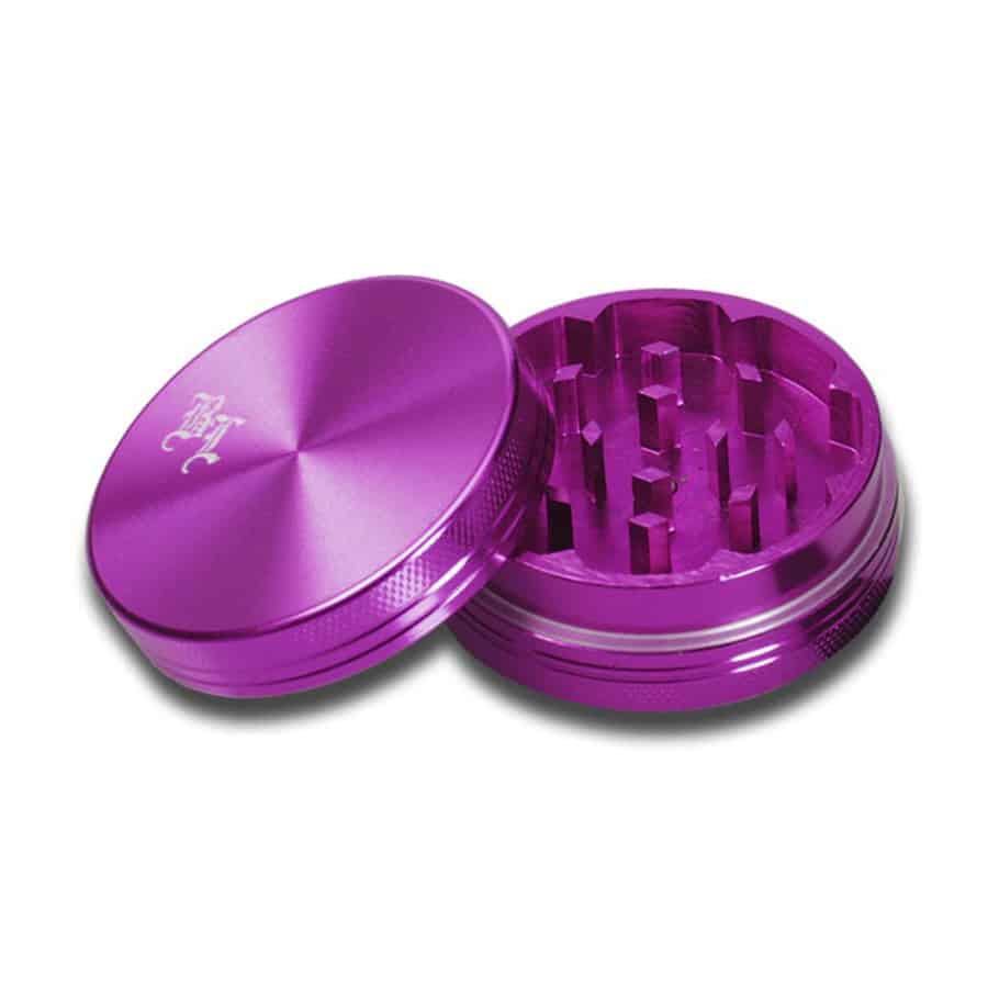 En sort krydderkværn med et blødt, mat finish pryder overfladen. Den har en diameter på 50 mm og en rund form. Øverste del er udstyret med en skarp tandet mekanisme til effektiv kværnning. Den nederste del har et gennemsigtigt vindue, der afslører indholdet. Det lilla indre tilføjer et kontrastfyldt farveelement.