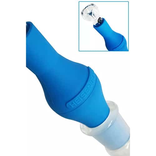 En aktivt kulfilter enhed præsenterer sig med en cylindrisk form og en sort, perforeret metalbelægning, der omgiver det indre filtermateriale. Overfladen er glat med en ensartet struktur. Toppen har en flad kant, og der er en tydelig åbning til luftgennemstrømning. Et mærke med tekst er placeret centralt, hvilket tilføjer information om produktet.