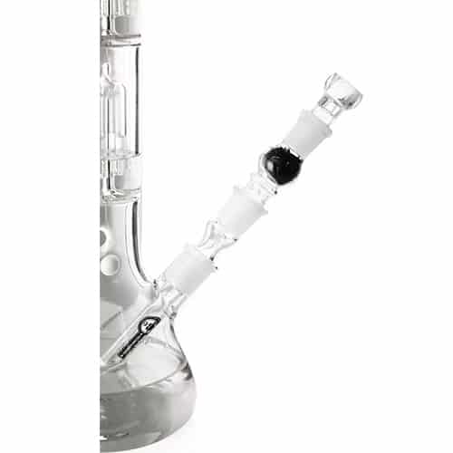Et klart glasrør med en diameter på cirka 18 mm er synligt, udstyret med en carbonfilter i bunden. Filteret er sort og har en porøs struktur, der muliggør væskegennemstrømning. Røret har en lige form og er lukket i toppen, hvor der er en åbning til påsætning af tilbehør. Overfladen er glat og reflekterer lys.