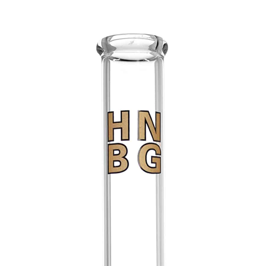 En guldfarvet perkolator med en højde på 50 cm præsenterer en slank, cylindrisk form. Overfladen er glat med en blank finish, der reflekterer lys. Toppen har en udvidelse, der afsluttes med en lille kegleformet del. Der er synlige rør og indvendige kamre, der skaber en kompleks struktur, mens bunden er bredere, hvilket giver stabilitet.