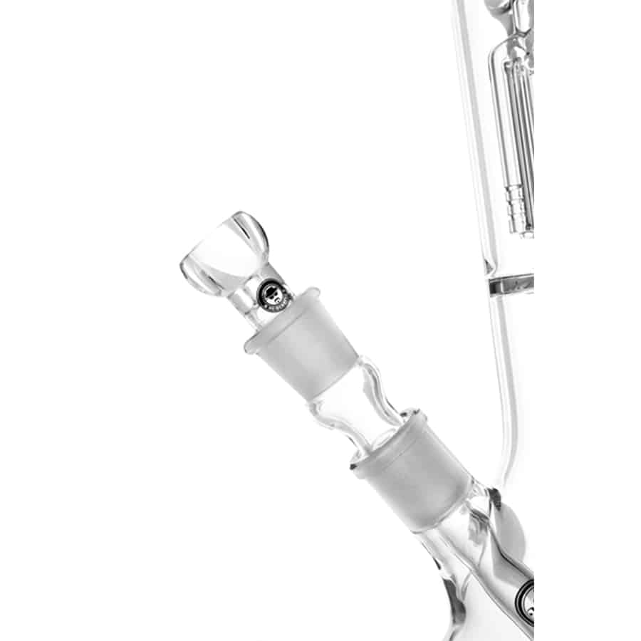 En guldfarvet perkolator i højglans med en slank, cylindrisk form og en bredere nederste del. Den har en klar, gennemsigtig beholder, der viser væsken indeni. Toppen er udstyret med en krum, metalrør, der bøjer sig over kanten. Overfladen har en glat tekstur, og der er detaljer som små udskæringer og en sort gummihåndtag for bedre greb.