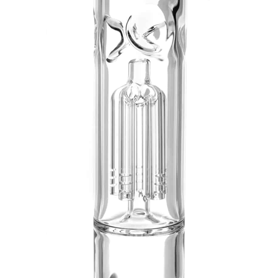 En høj, gylden perkolator i metal pryder midten af kompositionen. Den har en slank, cylindrisk form med en bredere bund og en smalere top, hvor en hældetud er placeret. Overfladen har en skinnende finish, der reflekterer lys. Detaljer som fine linjer og en cirkulær knap på toppen tilføjer dybde og dimension til designet.