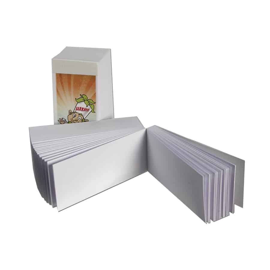 En række cylindriske filtertips fremstår i en klar, gennemsigtig emballage. Hver tip er hvid med en glat overflade og let bølget kant. På emballagen ses små, farverige grafiske elementer og tekst, der angiver produktinformation. Baggrunden er neutral, hvilket fremhæver filtertipsenes enkle design og funktionalitet.