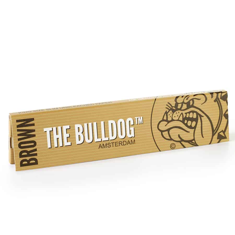 Brunt papir i king-size slim format med en glat overflade. Papiret er præcist skåret og viser en delikat, let struktureret tekstur. På papiret er der trykt hvid tekst med information om produktet, herunder mærkenavn og specifikationer. Kanterne er skarpe, og papiret er foldet let ved den ene ende for nem opbevaring.