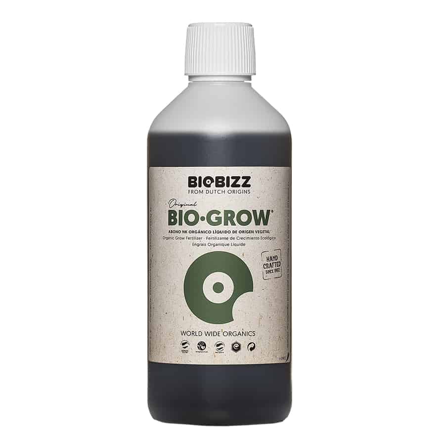 En transparent flaske med en brunlig væske. Flaskens form er cylindrisk, med en smal hals og en skruelåg i sort plast. Etiket i grøn og hvid med sort tekst præcist placeret på flaskens midte. Etiketten inkluderer et logo samt information om indhold og anvendelse. Flasken har en kapacitet på 0,5 liter.