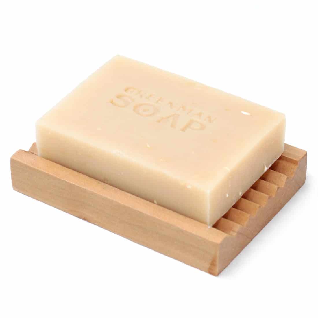 En firkantet sæbe i en blød, rundet form præsenteres med en lysegrøn farve. Overfladen er glat og skinnende, med en let transparent kvalitet. Sæben er indgraveret med et let mønster og tekst, der angiver produktnavnet. Den vejer 100 gram og har en simpel, men elegant fremtoning, der giver et indtryk af naturlighed og renhed.