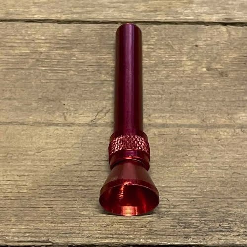 En rød slamrør i aluminium pryder billedet, med en glat og skinnende overflade, der afspejler lyset. Røret har en cylindrisk form og er udstyret med et bøjningselement, som giver det en kurvet profil. Ved røret er et bongsystem med en klar, gennemsigtig del, der viser indholdet, og en tæt metalforbindelse.