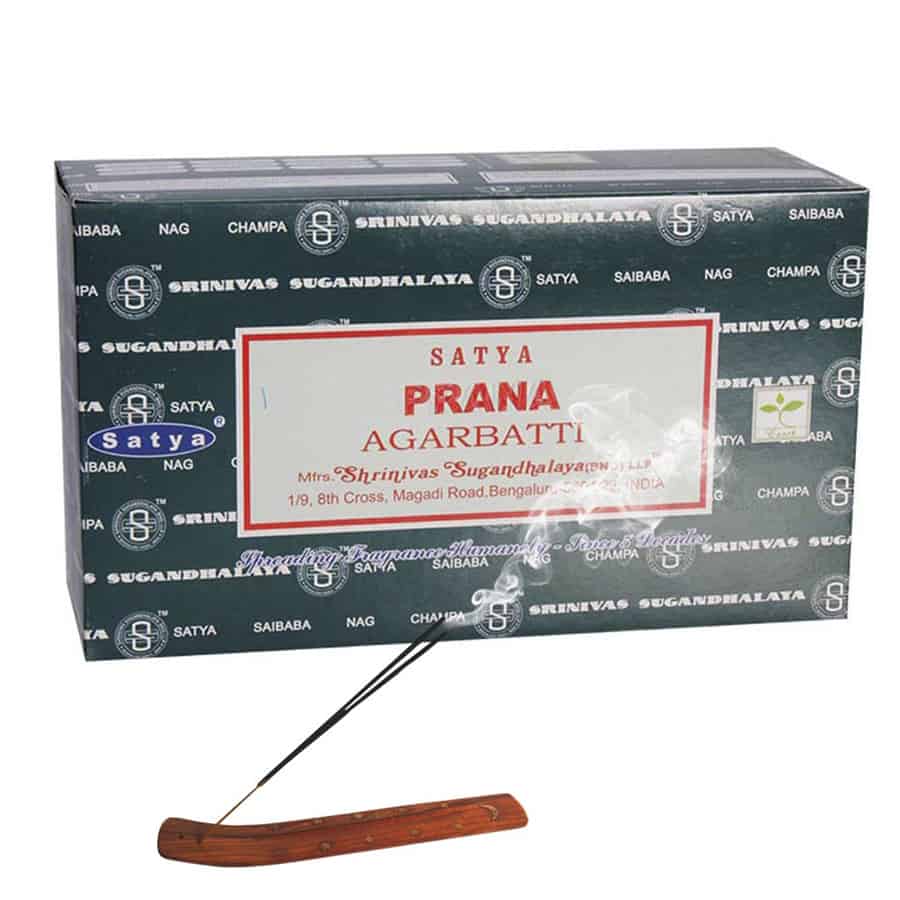 En række røgelsespinde præsenteres i et farverigt og dekorativt paprør. Pindene er slanke og lange med en ensartet brun overflade, mens røret er prydet med levende mønstre i nuancer af grøn, orange og guld. Toppen af røret er åbent, hvilket giver adgang til indholdet, der strækker sig i en lige linje.