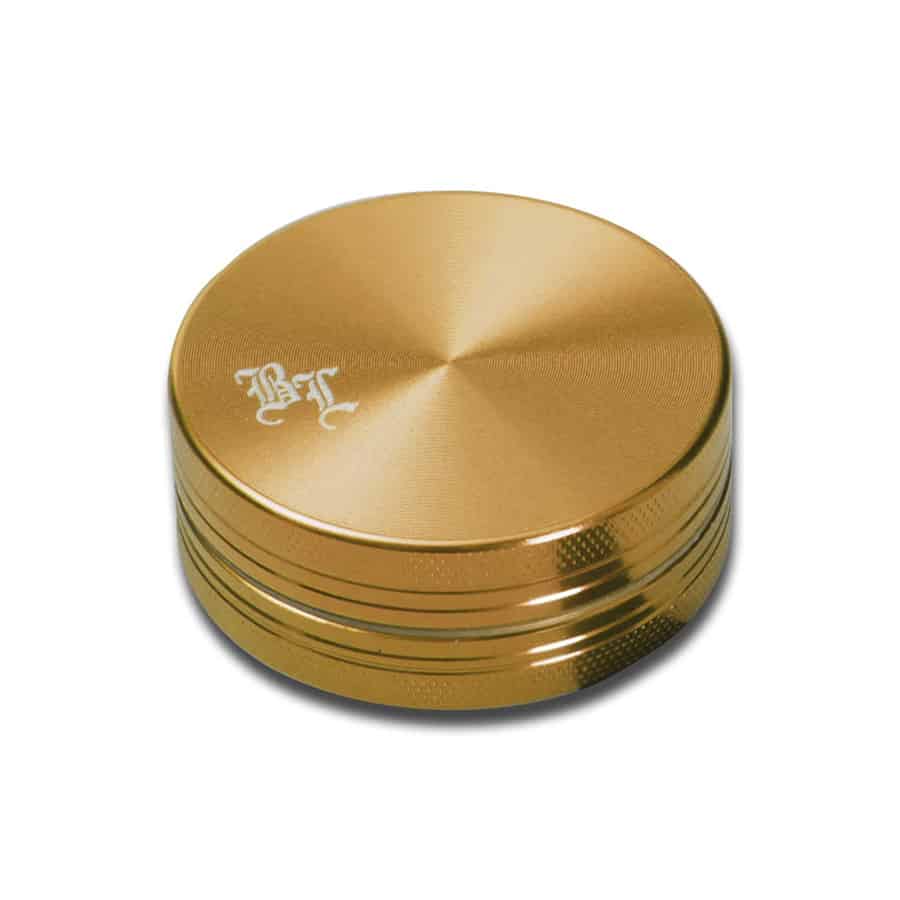 En sort urtepulverkværn med en diameter på 50 mm præsenterer sig med en glat, mat overflade. Kværnen har en flad top med en let hævet kant og en skarp, præcist udformet tandstruktur indeni. Der er en lille, tydelig åbning til påfyldning, mens bunden har små perforeringer til at slippe det malede materiale igennem. Kværnen har en kompakt, cylindrisk form.