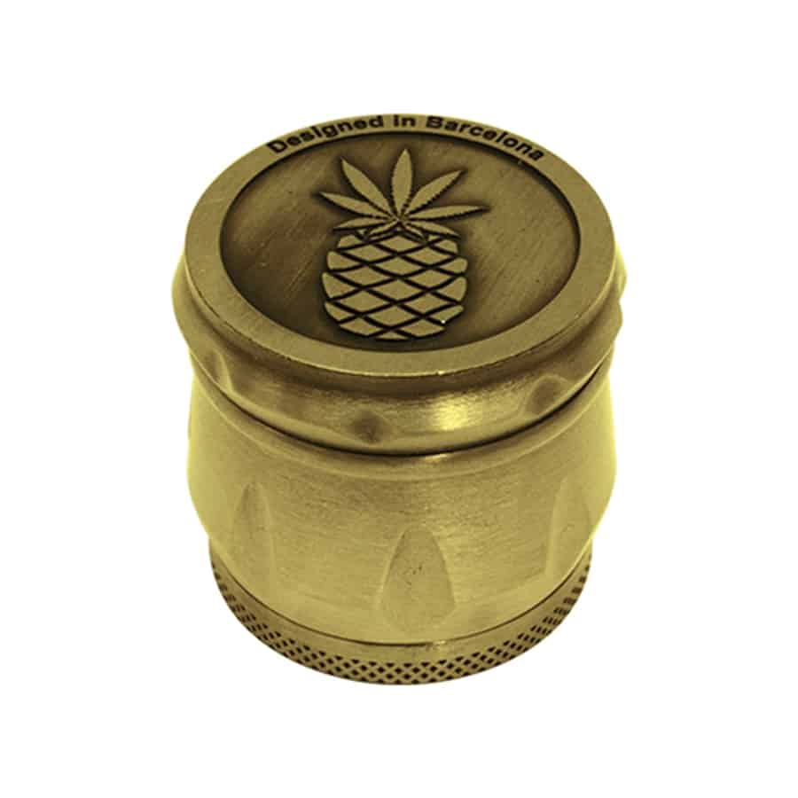 En gylden, prikket overflade dominerer objektets krop, der har en cylindrisk form. Toppen er udstyret med en skarp tandet mekanisme, der strækker sig ud over kanten. Mønsteret er detaljeret med små indhak og en let mat finish, hvilket giver en kontrast til den glatte overflade. Kanten er forsynet med en lille åbning, der muliggør let påfyldning.