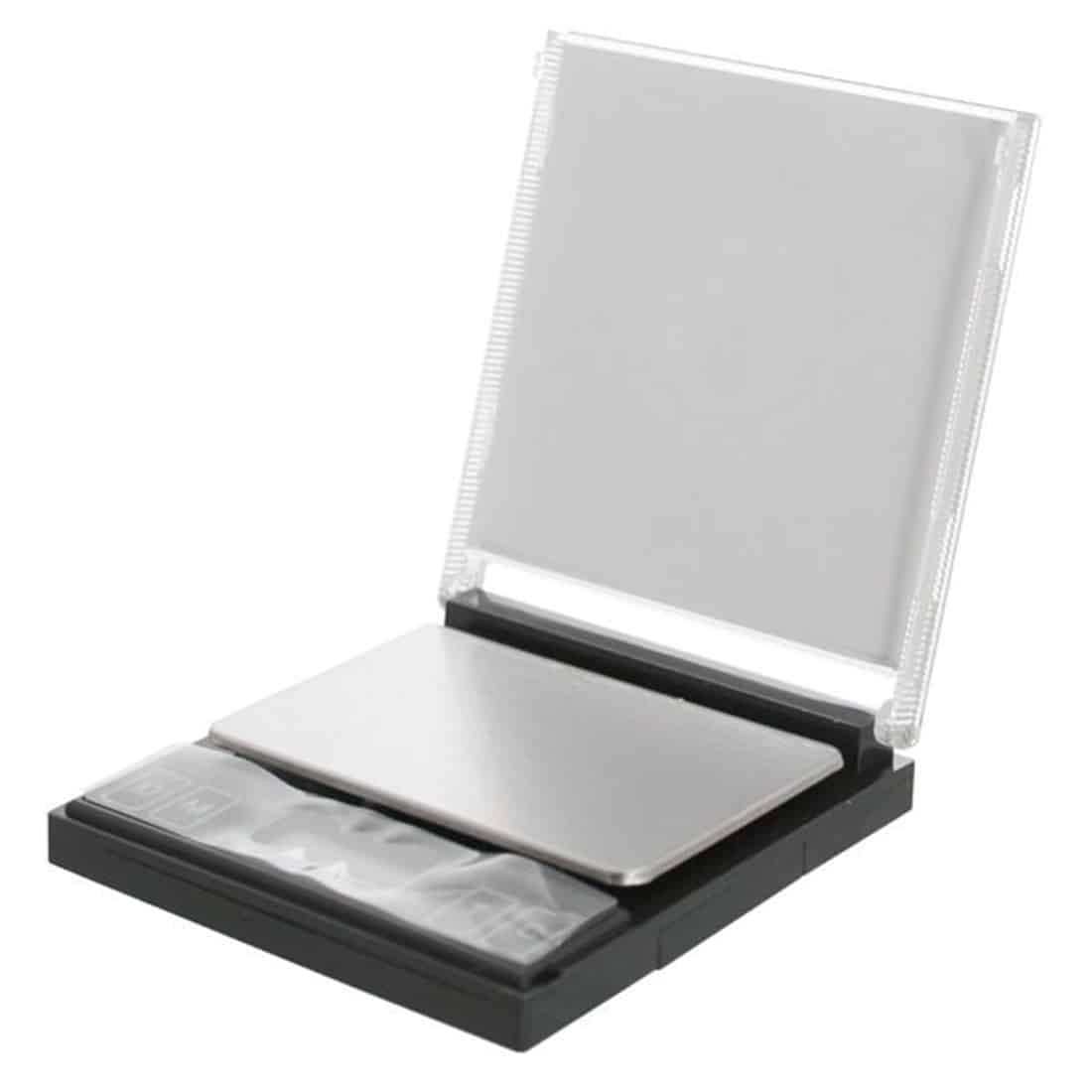 Skalaen har en firkantet, sort base med en glat overflade og afrundede kanter. Den digitale skærm er placeret på toppen, med tydelige, hvide sifre, der viser vægten i gram. Skalaens måleflade er lavet af klart glas, der giver en elegant finish. En lille, rød knap er placeret på siden for nulstilling.