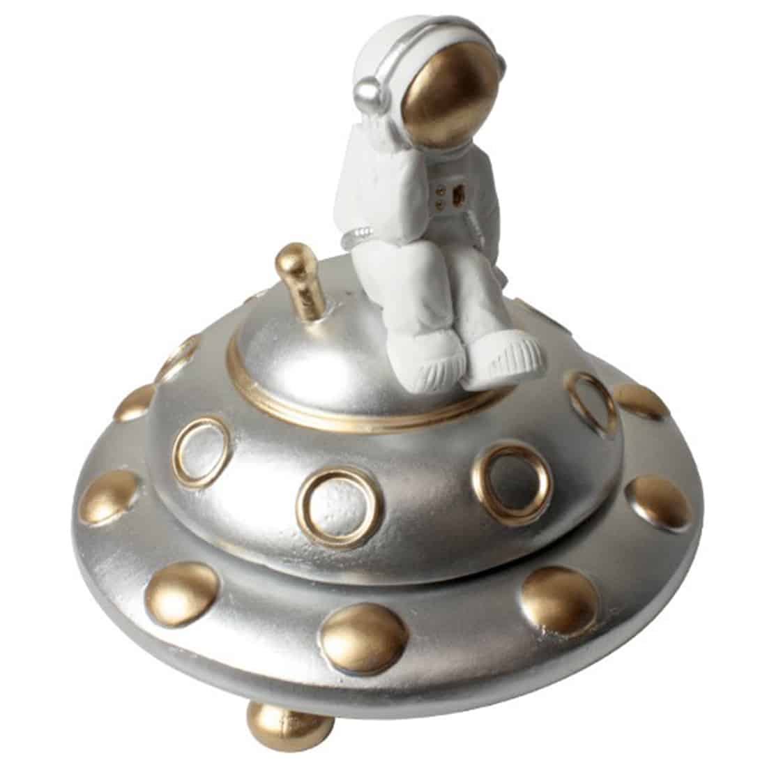 En skulpturel askebæger i form af et rumskib præsenterer sig med glatte, kurvede linjer og en metallic grå overflade. Det har en detaljeret cockpit sektion med en transparent kuppel, der giver indblik til det indre. Bunden er bred og stabil, mens der er små, fine detaljer som motorer og vinger, der tilføjer dybde og karakter.