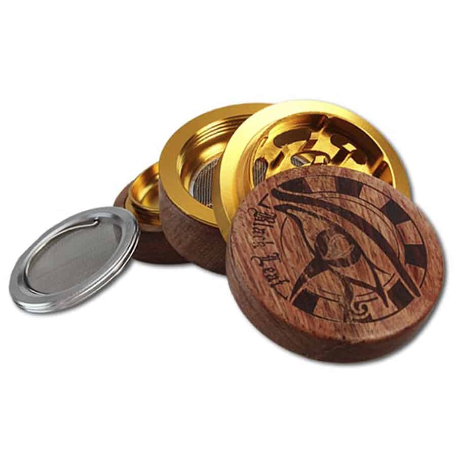 En sort bladformet kværn er fremstillet af ægyptisk træ, kendetegnet ved en glat, mat overflade. Kværnen har en rund base med en let skråning, der fører op til den flade, bladlignende top. Det mørke træ har en rig, dyb farve med fine åretegninger, som tilføjer struktur til det samlede udseende. Kværnen har en central åbning til påfyldning.