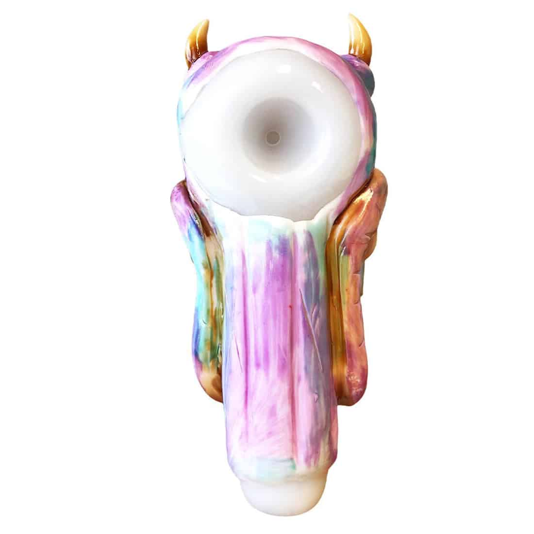 En sort glasrørformet pibe pryder midten af kompositionen, karakteriseret ved en glat overflade og en let buet form. Piben har en monstrede udseende med en stor, rund øje og detaljerede, skræmmende ansigtstræk i kontrasterende farver. Øjets iris er i nuancer af grøn og guld, hvilket giver en livlig kontrast til det sorte glas. Piben måler 150 mm i længden.