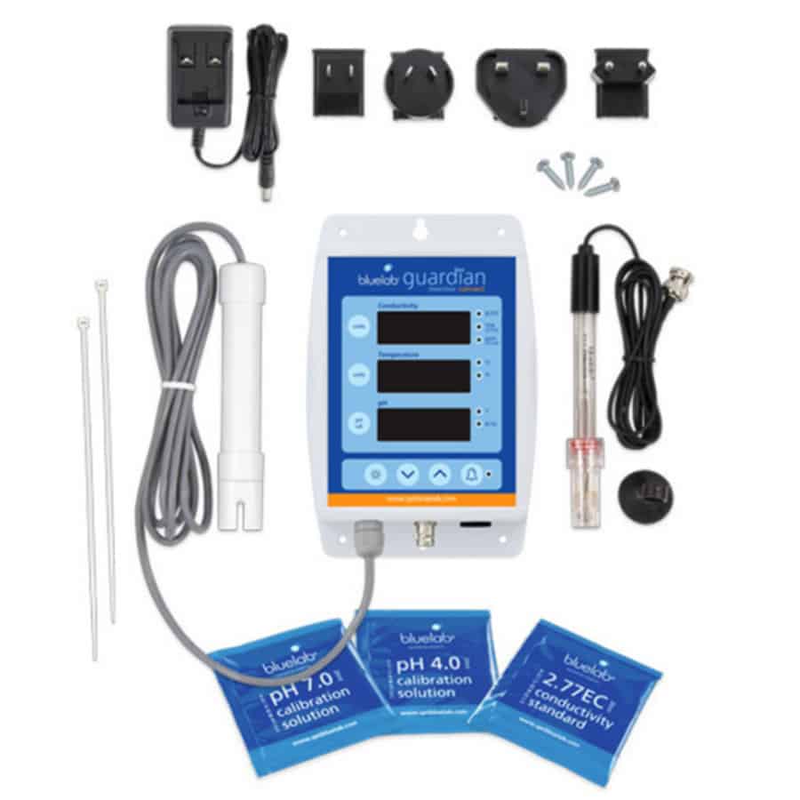 Guardian Monitor Connect præsenterer sig med en rektangulær, flad skærm i sort plastik med en glat overflade. Skærmen viser en farverig digital visning af forskellige målinger, herunder pH og elektrisk ledningsevne, præsenteret med klare, letlæselige tal. Under skærmen findes tre knapper, der er placeret symmetrisk, og en tilslutningsport er synlig på siden. Baggrundsfarven er lys, hvilket fremhæver de grafiske elementer.