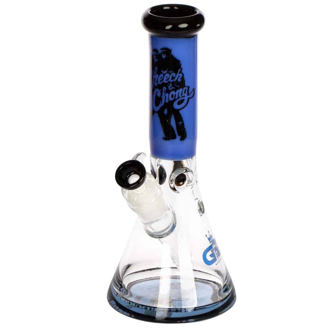 En beaker bong i klart glas præsenterer sig med en bred, stabil bund og en slank hals, der afsluttes med et krum top. Den har en dybblå farve, der pryder halsen og toppen, med en glat overflade. Bongen er udstyret med en nedadgående perkolator og en skål, der er designet til at passe perfekt ind. Detaljer som små bobler og reflekterende overflader tilføjer visuel interesse.