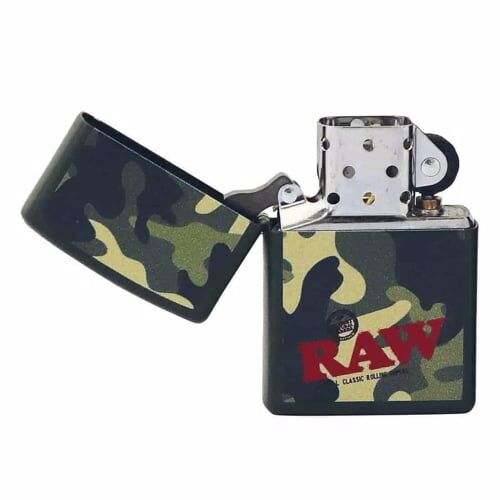 En kamuflage-mønstret lighter præsenteres i en blanding af grønne, brune og sorte nuancer, der skaber et militært udseende. Lighterens metaloverflade har en glat glans, med en tydelig zippo-logo placeret på forsiden. Kanten er afrundet, og låget har en hængslet mekanisme, der giver mulighed for at åbne og lukke let.