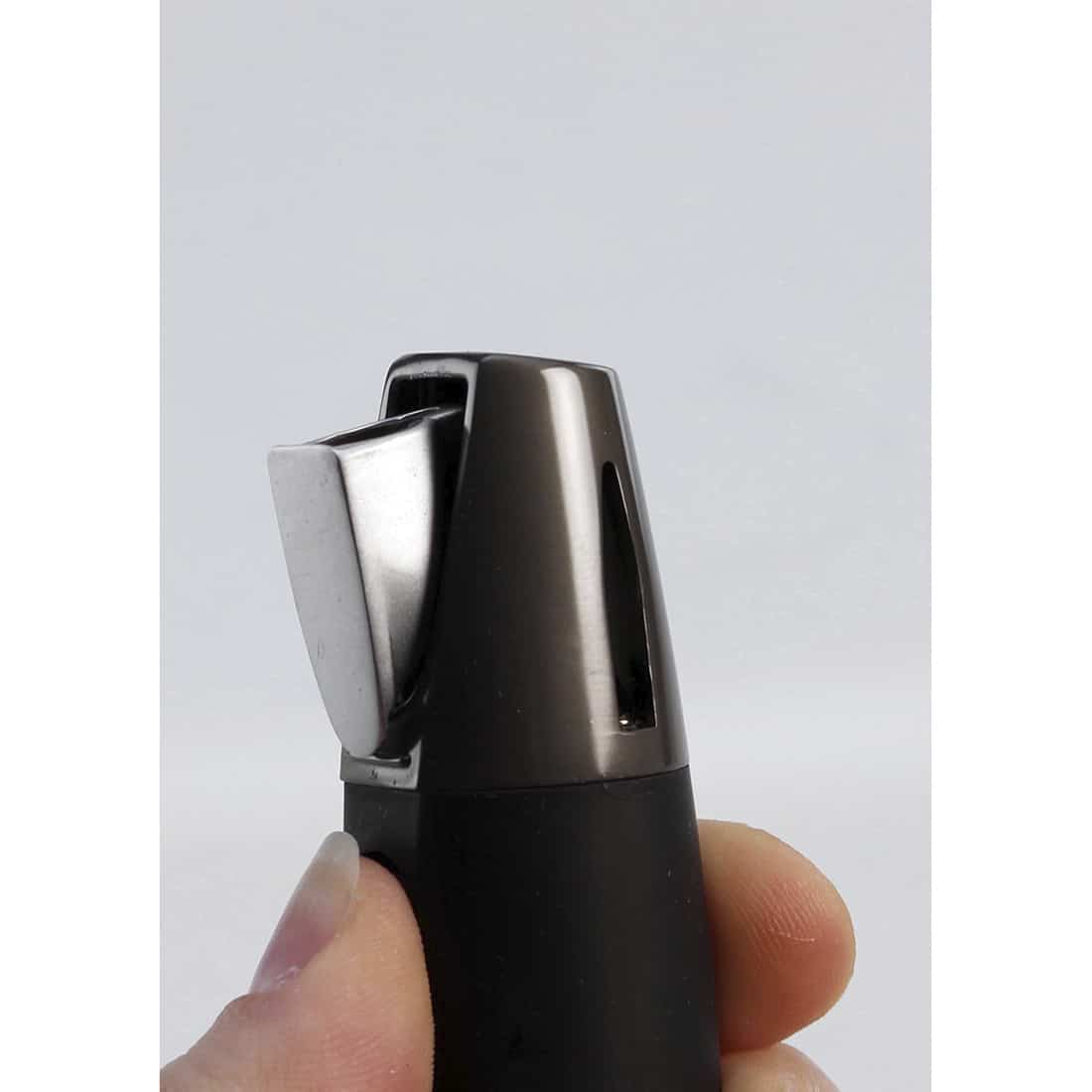 En elektrisk jet-flame lighter præsenterer sig i en dyb, metallic sort farve med en glat overflade. Den har en slank, rektangulær form med afrundede kanter. Foran findes en tændknap i sølvfarve, der er let fremhævet. Øverst er et vindue, der afslører gasniveauet, mens flammen, når tændt, fremstår som en intens, blå stråle.