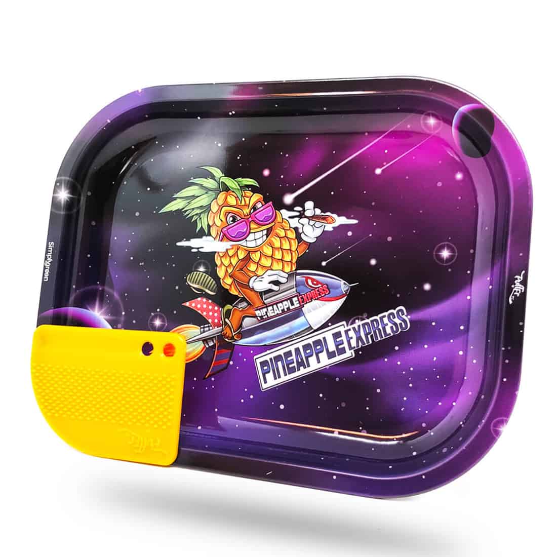 En lille mixerbakke i metal prydet med et farverigt design af ananas og cannabisblade. Bakken har afrundede kanter og en glat overflade, der reflekterer lys. Ved siden af ligger en lille grinder i sort plast med en ru tekstur og perforerede skiver. Farverne i designet spænder fra grøn til gul, hvilket skaber en livlig kontrast.