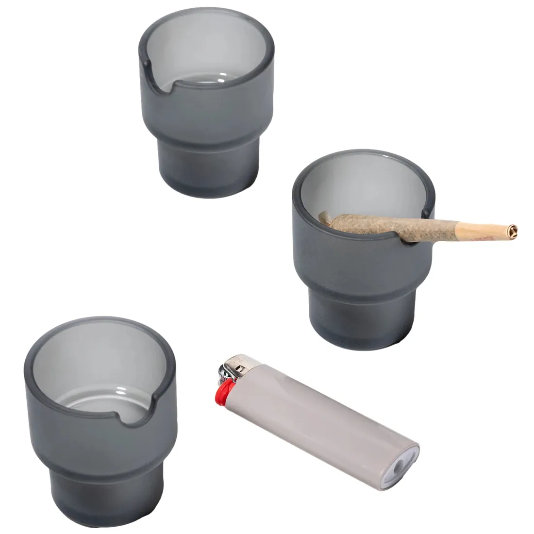 Et sæt af tre askebægere i en dyb, grå kulør pryder overfladen. Hver askebæger har en rund form med en glat, mat tekstur, der giver et moderne udtryk. De er placeret tæt sammen, hvilket skaber en harmonisk komposition. Hver bæger har en skarp kant, der kontrasterer med den bløde form, hvilket tilføjer en subtil elegance.