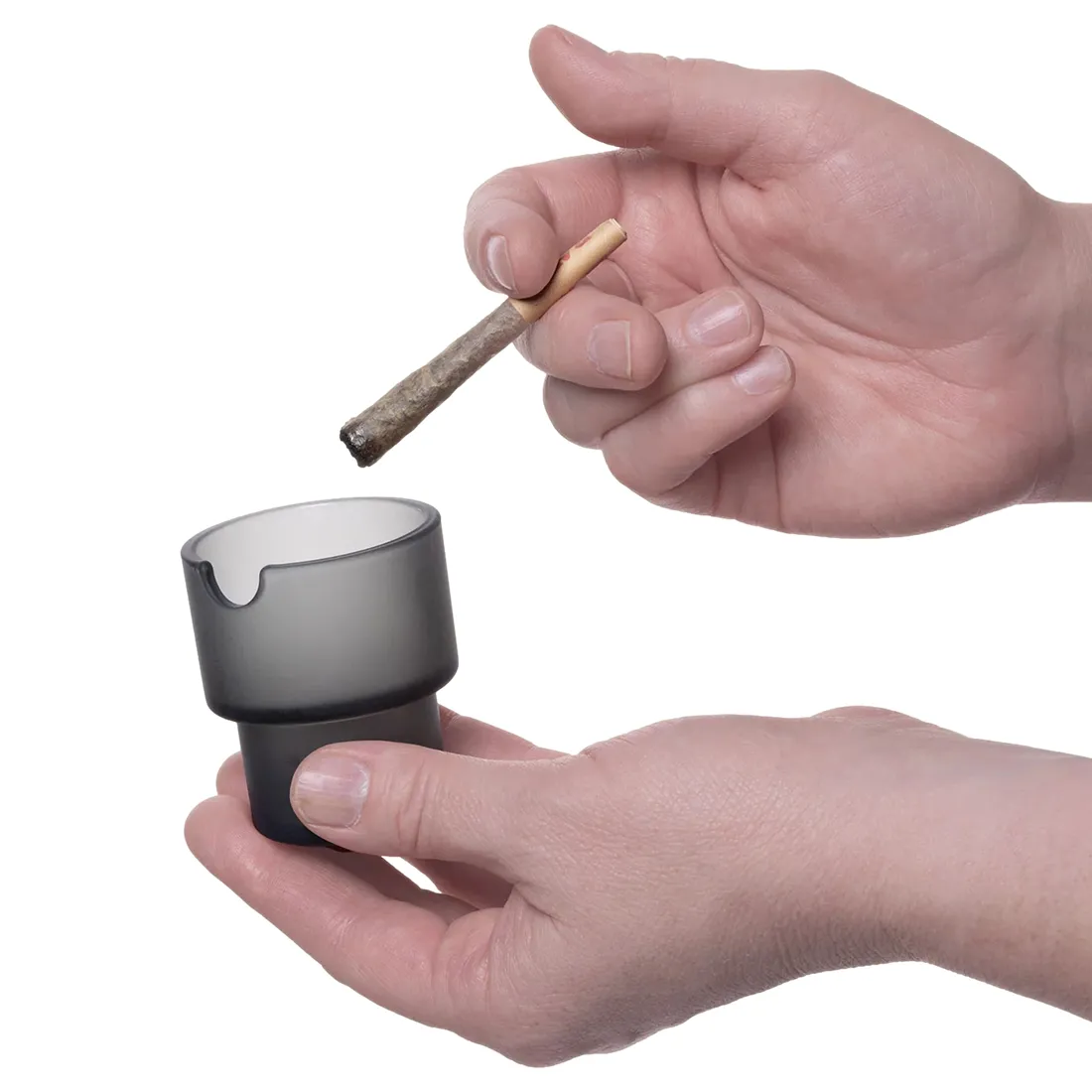 En skålformet askebæger i mørkegrå keramik præsenterer sig med en glat, mat overflade. Den har en rund bund, der bredner sig mod toppen, hvilket skaber en elegant silhuet. Indvendigt er der en let glans, mens ydersiden har en ensartet struktur. Askebægeret har en diskret kant og er uden synlige mærker eller dekorationer.