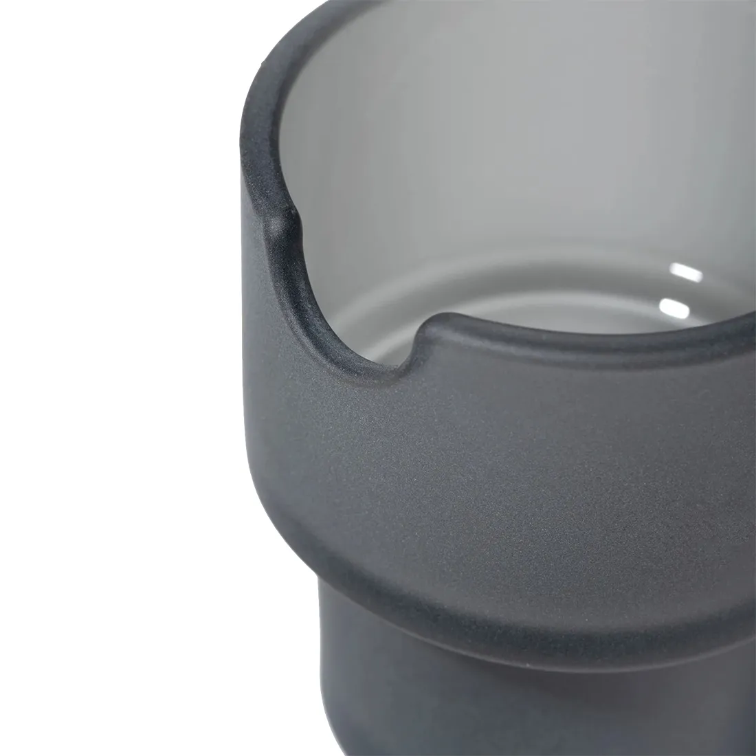 En sort askebæger i mat finish præsenterer sig med en rund, flad base, der glider op til en let hævet kant. Overfladen har en ensartet struktur, som giver et moderne udtryk. Indvendigt findes en glat, blank belægning, der øger kontrasten. Askebægeret har en diskret, elegant form, der passer ind i minimalistiske omgivelser.