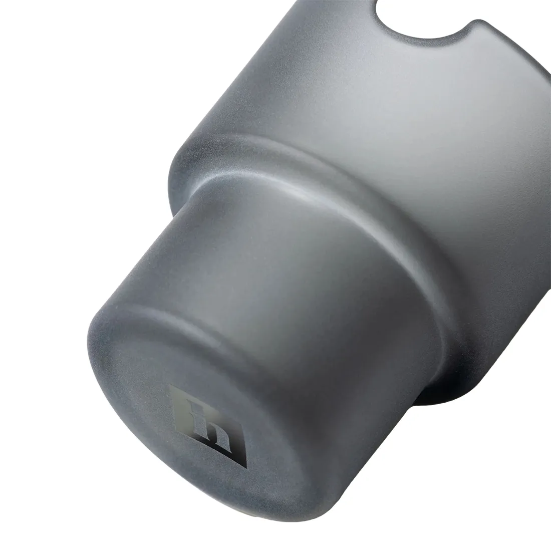 Et askebæger i mørkegrå farve, fremstillet af keramik, præsenterer en glat overflade med en let glans. Bunden er bred og stabil, mens kanten er let udadvendt, hvilket giver en blød silhuet. Indvendigt ses en dyb skålform med en subtil struktur. Askebægeret har en minimalistisk og moderne æstetik, velegnet til indendørs brug.