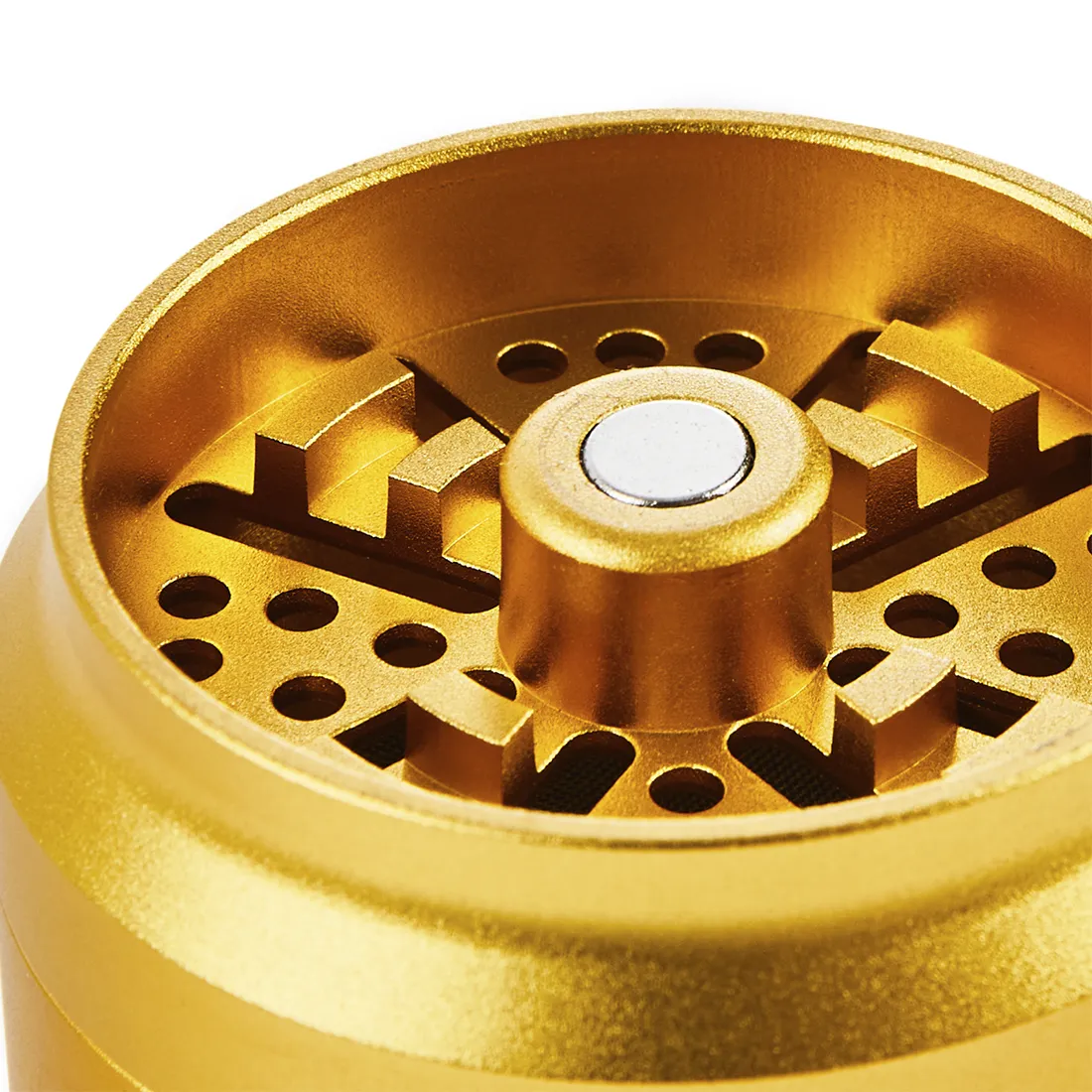 En gylden krydderkværn med en diameter på 55-63 mm fremstår i et slebet metalfinish, der reflekterer lys. Overfladen er glat med fine detaljer, som små riller langs kanten. Kværnen har en skruelåg med et indgraveret mønster, der tilføjer tekstur. Indvendigt ses skarpe tænder til formaling af urter. Kværnen er kompakt og robust i design.