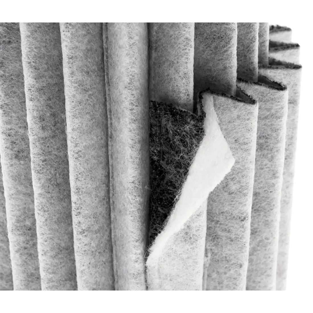 Nærbillede af lagdelt gråt og hvidt stof afslører en struktureret overflade nedenunder, der ligner præcisionslaglægningen af et Garden HighPro - ProActive Kulfilter. Det strukturerede stof, foldet lodret i folder, afspejler filterets omhyggelige design.