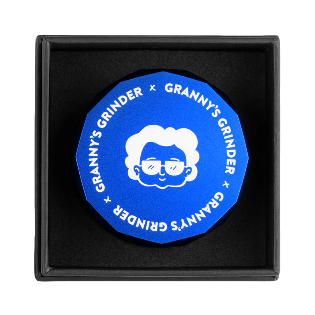 En hexagonformet kværn i en blå farve med en diameter på 55 mm. Overfladen har en glat tekstur med en let metallisk glans. Kværnen består af flere sektioner, herunder en top med skarpe tænder til kværning. Der er små hulrum til at samle det kværnede materiale. Kværnen har en robust konstruktion, der indikerer holdbarhed.