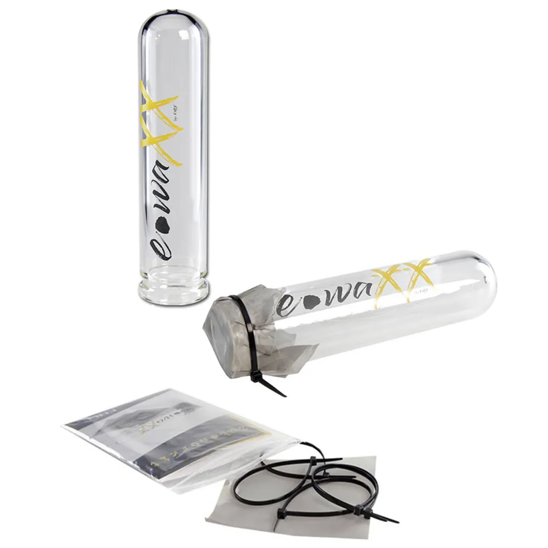 En transparent, cylindrisk beholder med en glat overflade, fremstillet af klart glas. Den har en bred åbning øverst og en smalere bund, hvilket giver en elegant form. Øverst ses en let skrånende kant, og på siden findes en tydelig, farvet logo-etiket. Beholderen står på en flad, lys overflade, hvilket fremhæver dens klare materialer.